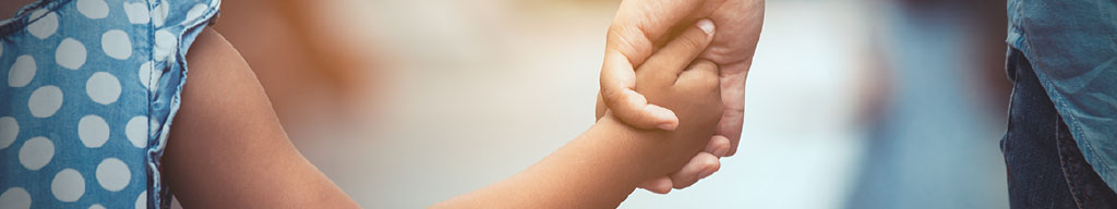 Close-up image of child and parent holding hands - Modernisation du droit de la famille website banner