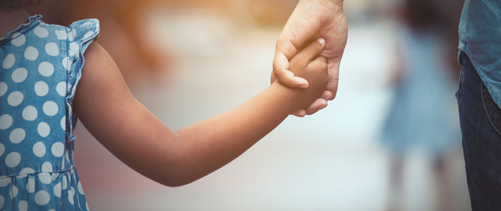 Close-up image of child and parent holding hands - Modernisation du droit de la famille website banner