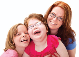 woman and two children smiling and hugging