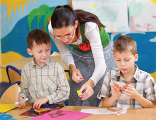 woman helping two children with a craft