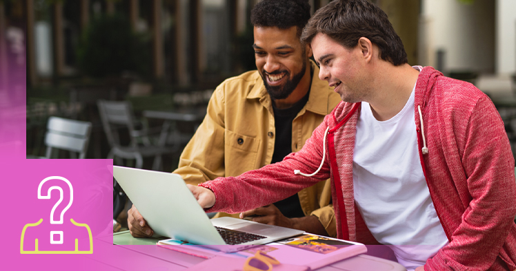 Two people sitting at a desk working on a laptop